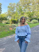 Beautiful blue embroidered fabric blouse with shirring at the waist and an off shoulder look. The long sleeves are billowy and gathered in several places. Easy sewing pattern by Ellie and Mac Sewing patterns. 
