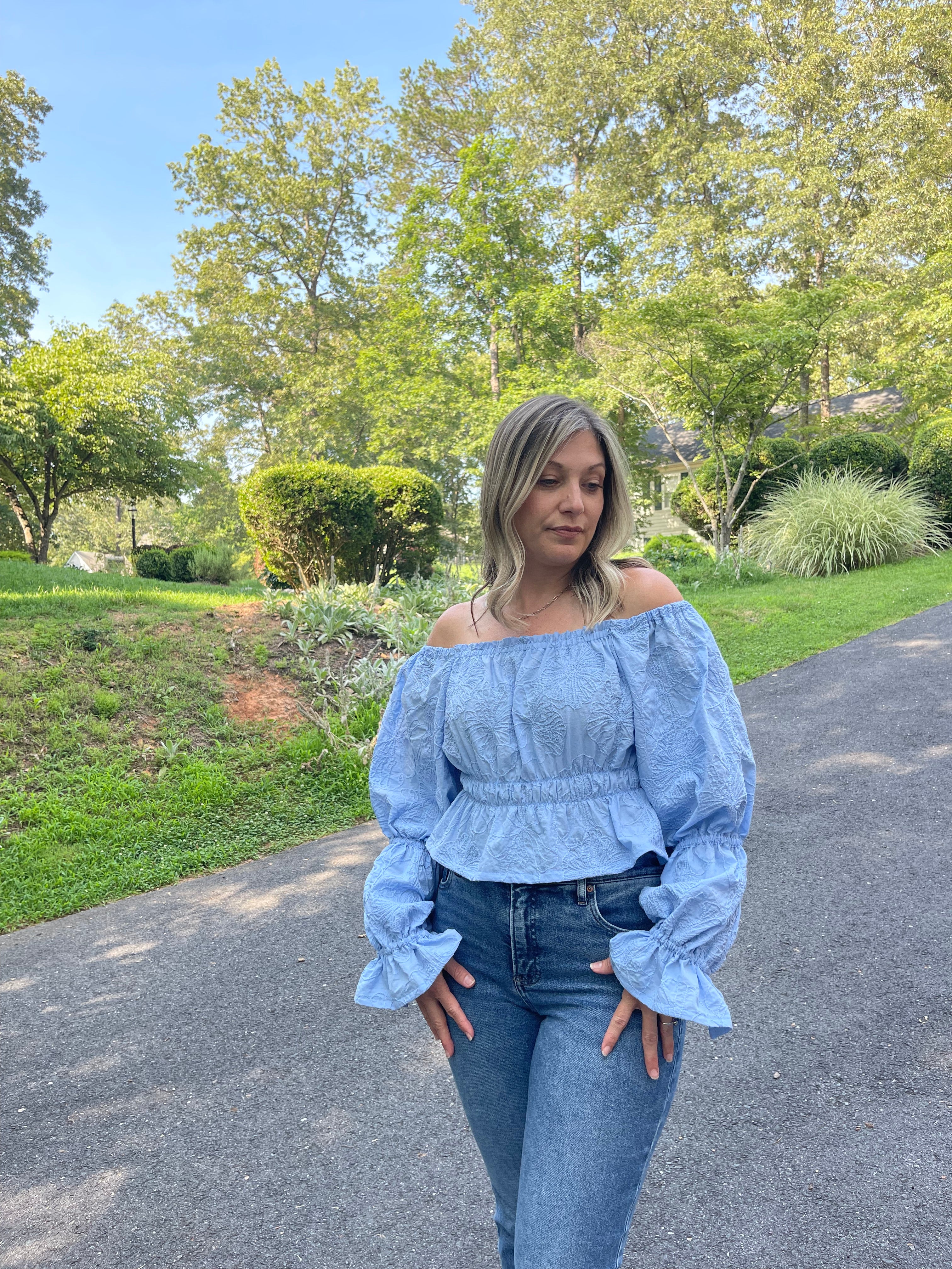 Beautiful blue embroidered fabric blouse with shirring at the waist and an off shoulder look. The long sleeves are billowy and gathered in several places. Easy sewing pattern by Ellie and Mac Sewing patterns. 