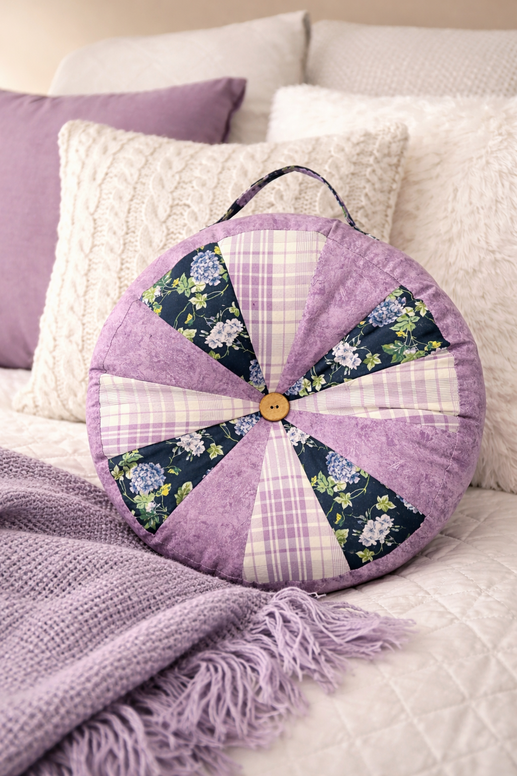 Patchwork cushion with floral patterns on a sofa with pillows and blanket. Sewn using the Ellie & Mac Sprocket Pillow Pattern. Easy PDF sewing pattern.