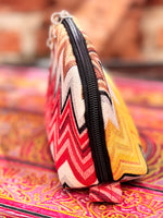 Colorful woven pouch, made with the Tessa pouch pattern, with a zigzag pattern on a patterned surface