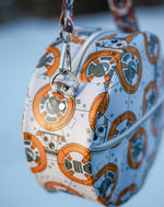 Handcrafted round vinyl bag in BB print with silver hardware and hidden strap connectors.