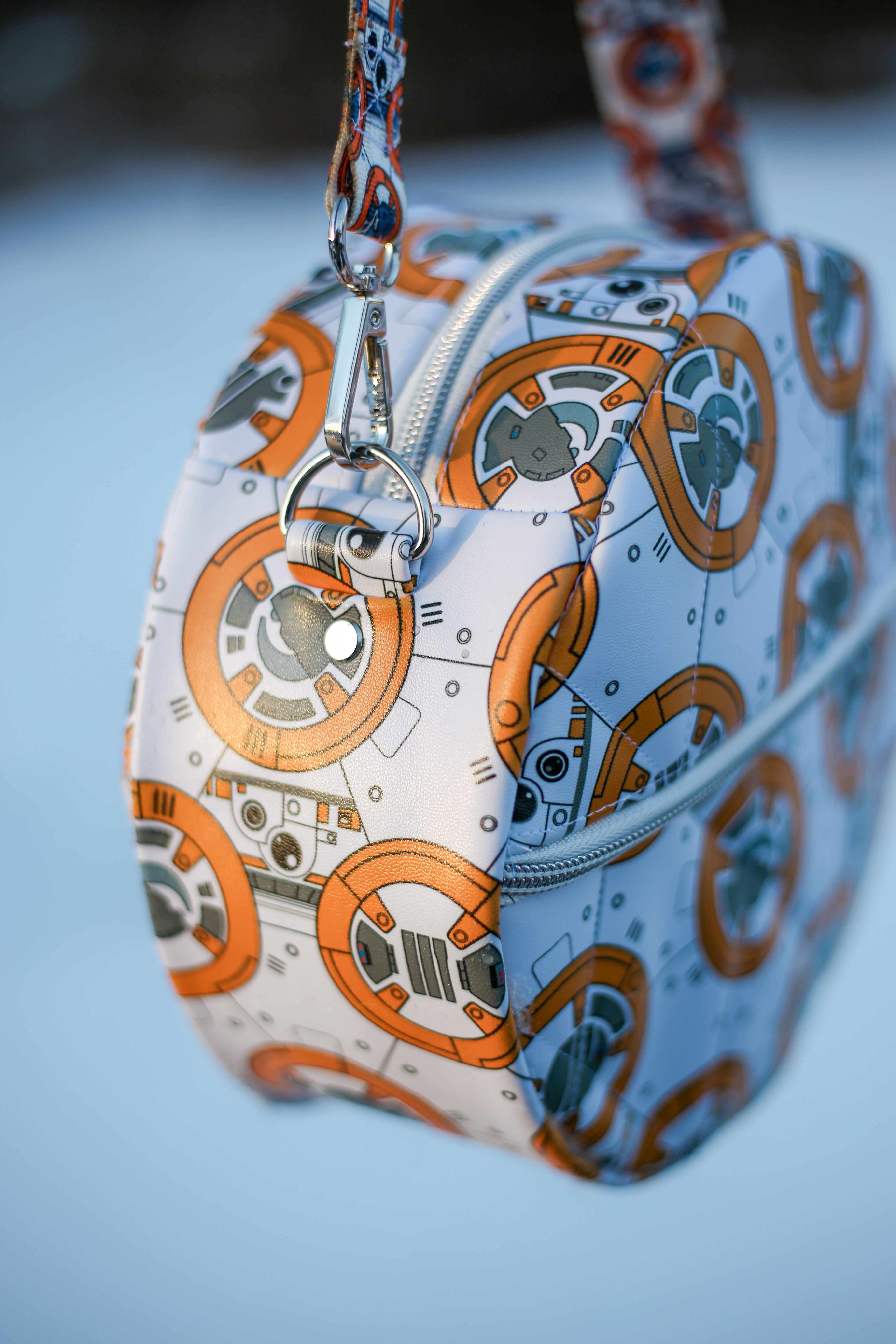 Handcrafted round vinyl bag in BB print with silver hardware and hidden strap connectors.