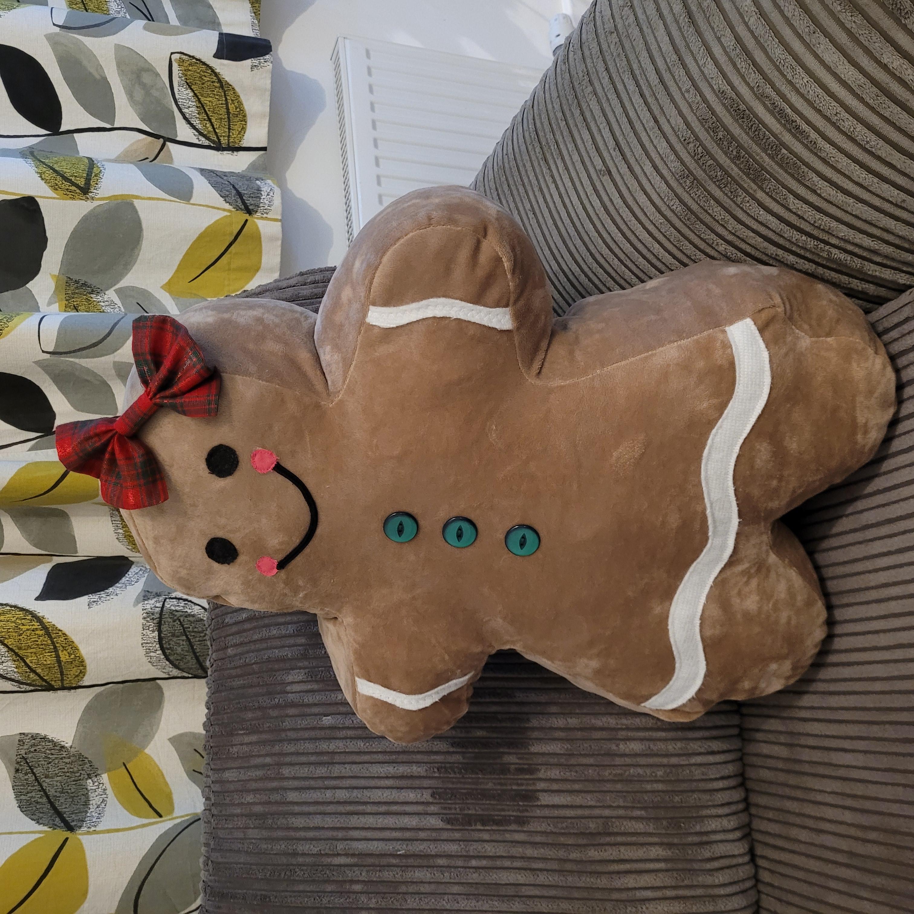Side angle view of the Gingerbread pillow highlighting stuffed shape and silhouette.