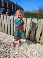 Ladybug fabric dress with faux wrap bodice and short sleeves. 1/2 Circle skirt with pockets. Toddler to teen sewing pattern.