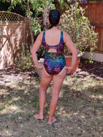Person wearing a colorful swimsuit standing outdoors in a garden setting.