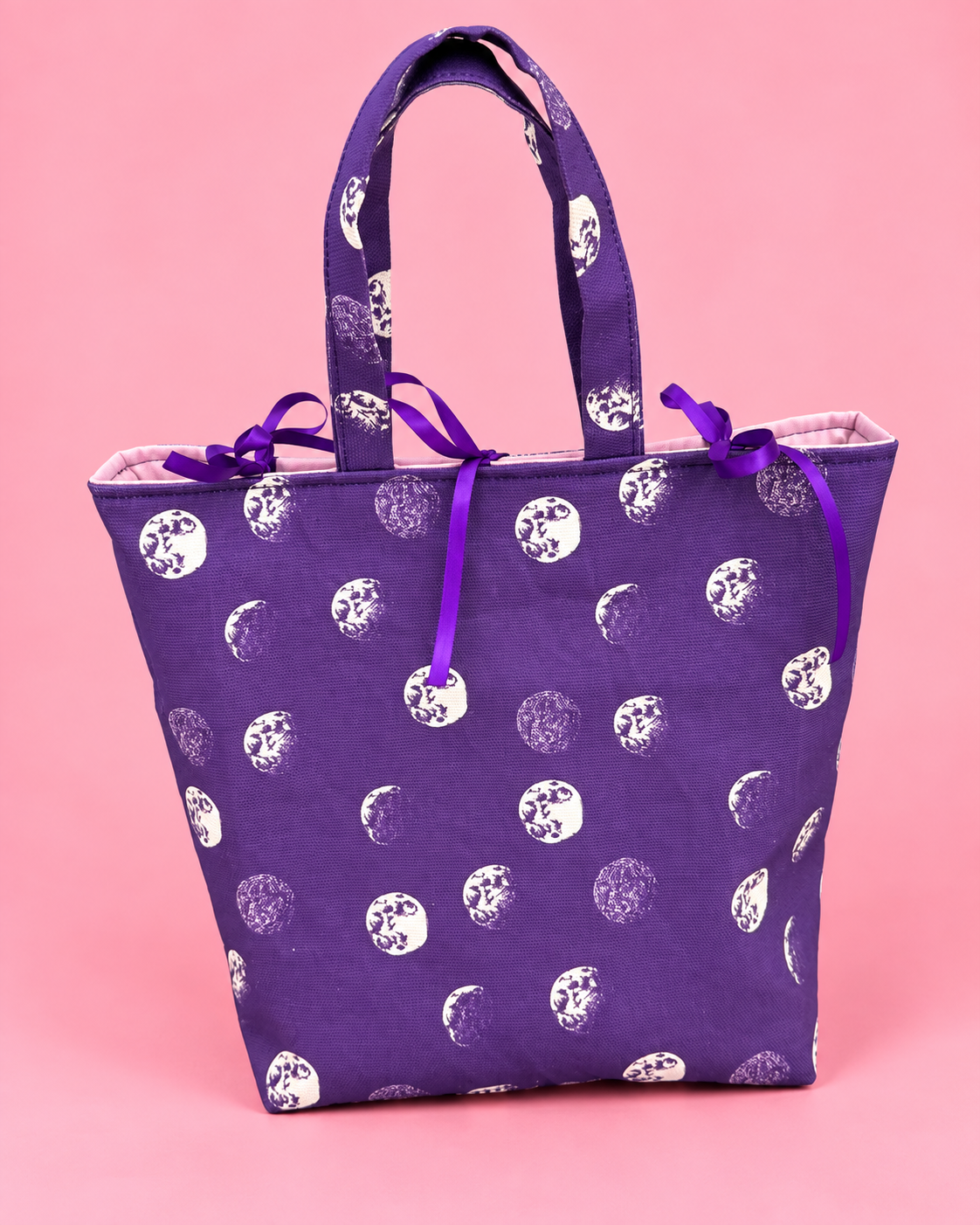 Purple moon print structured gift bag with ribbon ties and handles
