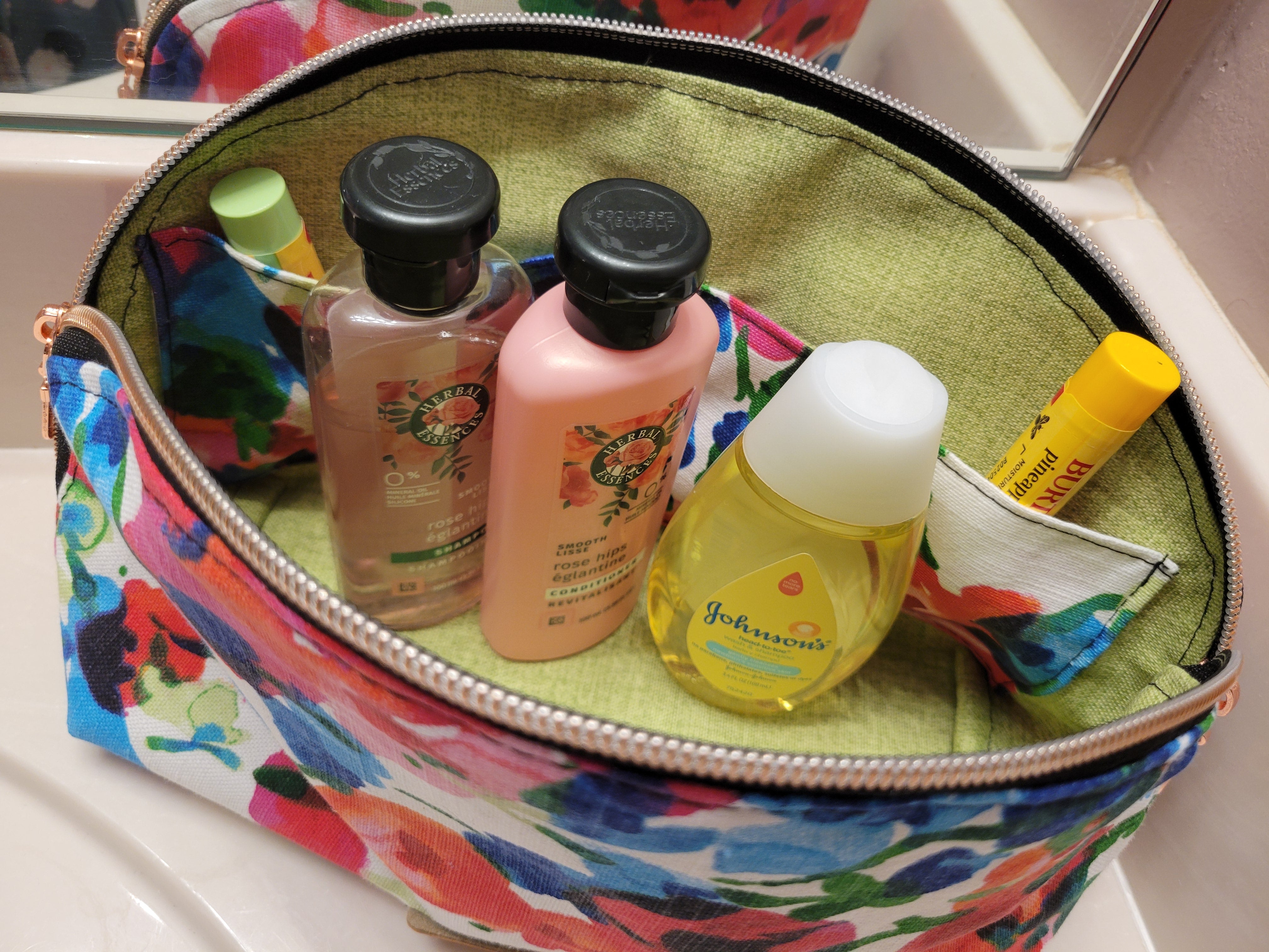 Colorful makeup bag with toiletries including bottles and a yellow tube.