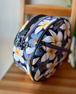 Floral-patterned round bag on a wooden surface. Side view.