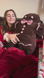 Gingerbread Man pillow displayed on a holiday couch setting.