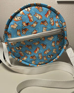 Round crossbody bag with corgi pattern on a flat surface