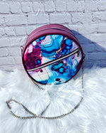 Handcrafted round vinyl bag in mauve purple with silver hardware and hidden strap connectors.