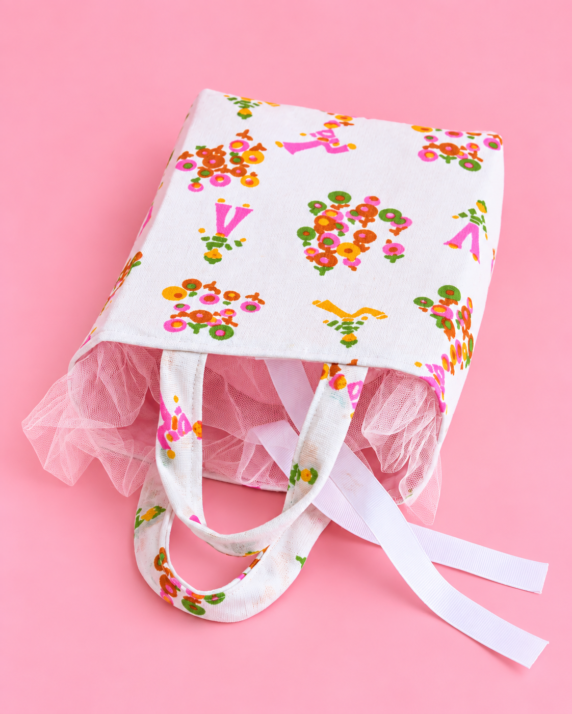 Small structured fabric gift bag with decorative handles and tulle