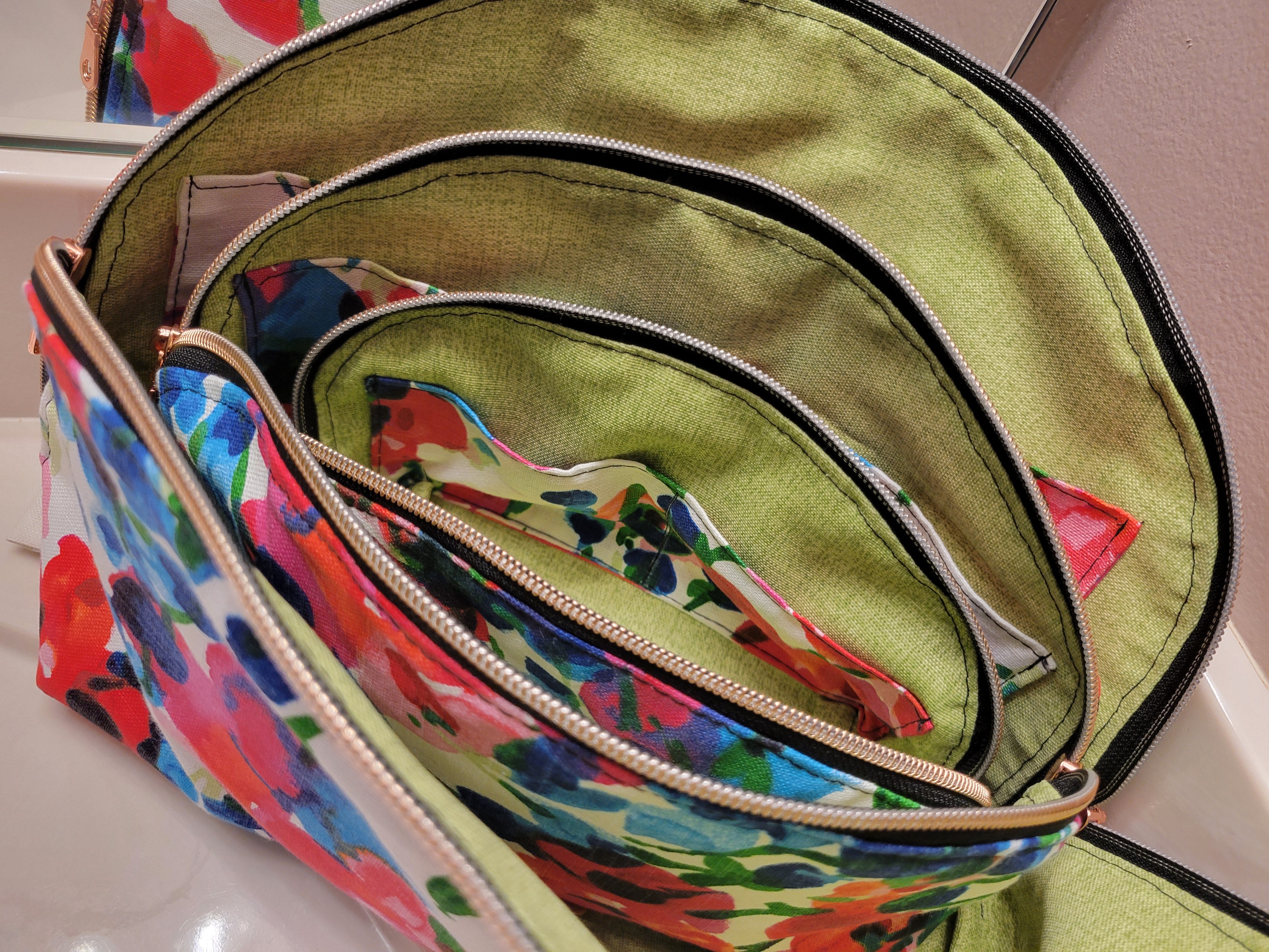 All three sizes of the Tessa Toiletry Pouch displayed together in a styled format.