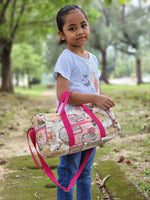 Handmade duffle bag in travel woven fabric, showcasing its zipper exterior pocket, pink adjustable straps, and small size. Great for kids. PDF sewing duffle bag pattern.