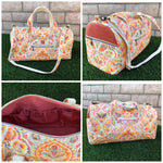 Handmade duffle bag in pretty woven fabric, showcasing its zipper exterior pockets, pink adjustable straps, and interior pockets. Great for travel. PDF sewing duffle bag pattern.
