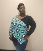 Woman wearing a teal large-scale cheetah print and black crossover top Made using the Beginner-friendly wrap top sewing pattern with crossover front and curved hem