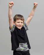 Child wearing a black t-shirt with car designs on a gray background