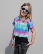 Girl in colorful short sleeve crop top and sunglasses. 