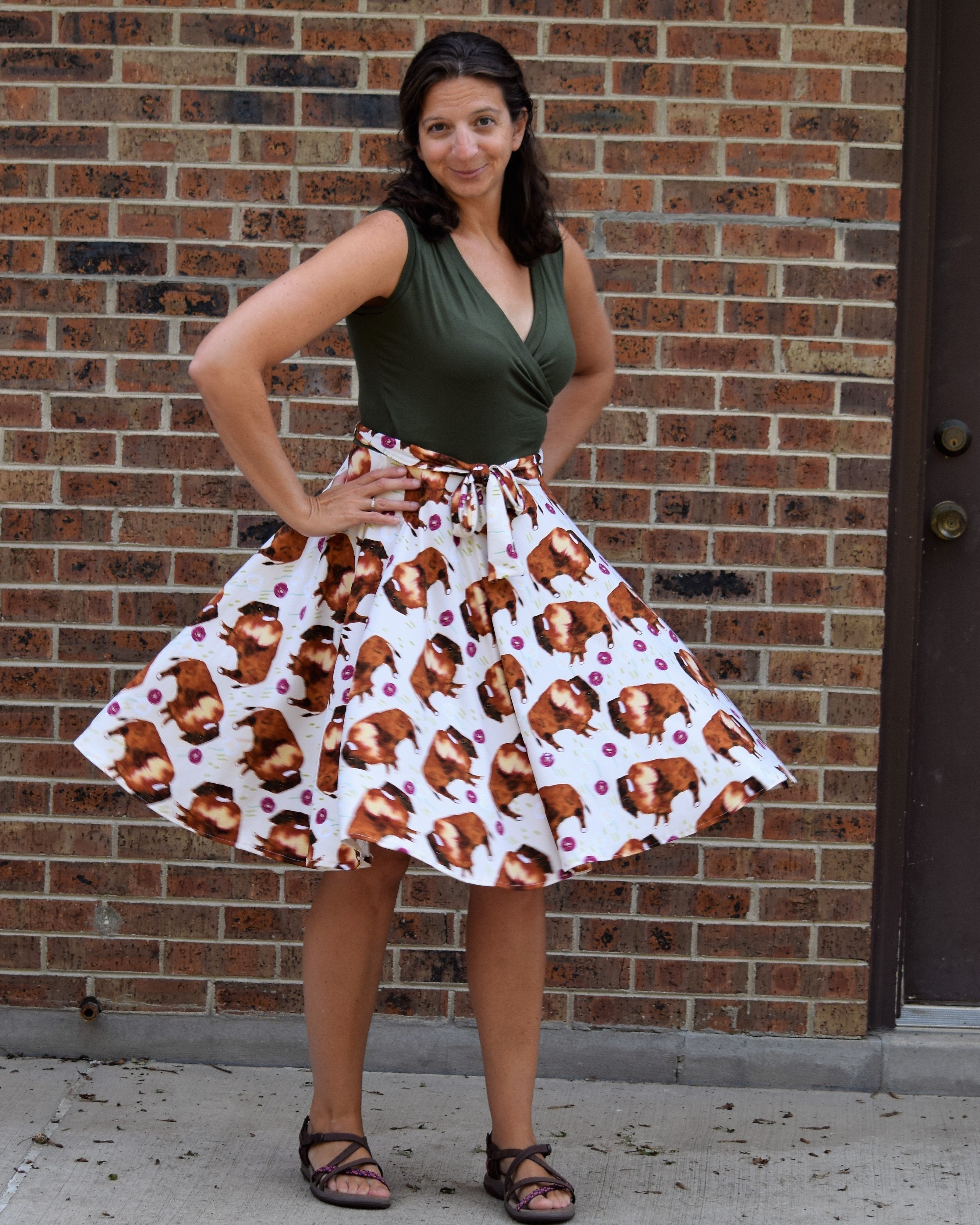 Woman wearing a skirt with pig pattern in front of a brick wall