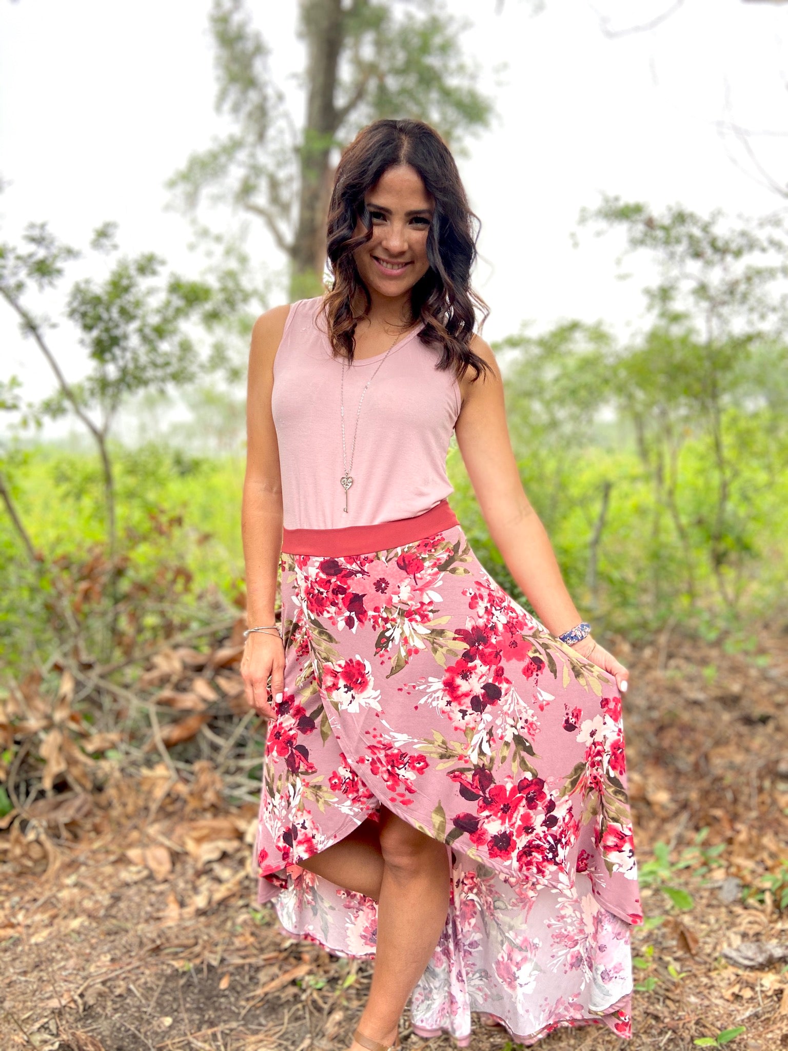Woman modeling a wrap front skort with colorful floral knit fabric. Cute high-low hemline sewing pattern. Comfort and style with this easy sewing pattern for knit fabrics. Modest sewing.