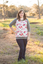 Women wearing a floral top with tan raglan sleeves, neckband, and waistband. The top is hip length and relaxed. 