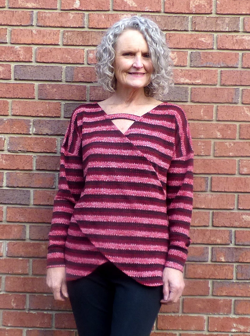 Woman wearing a striped sweater made from an Easy sew dolman sleeve wrap top PDF pattern for women