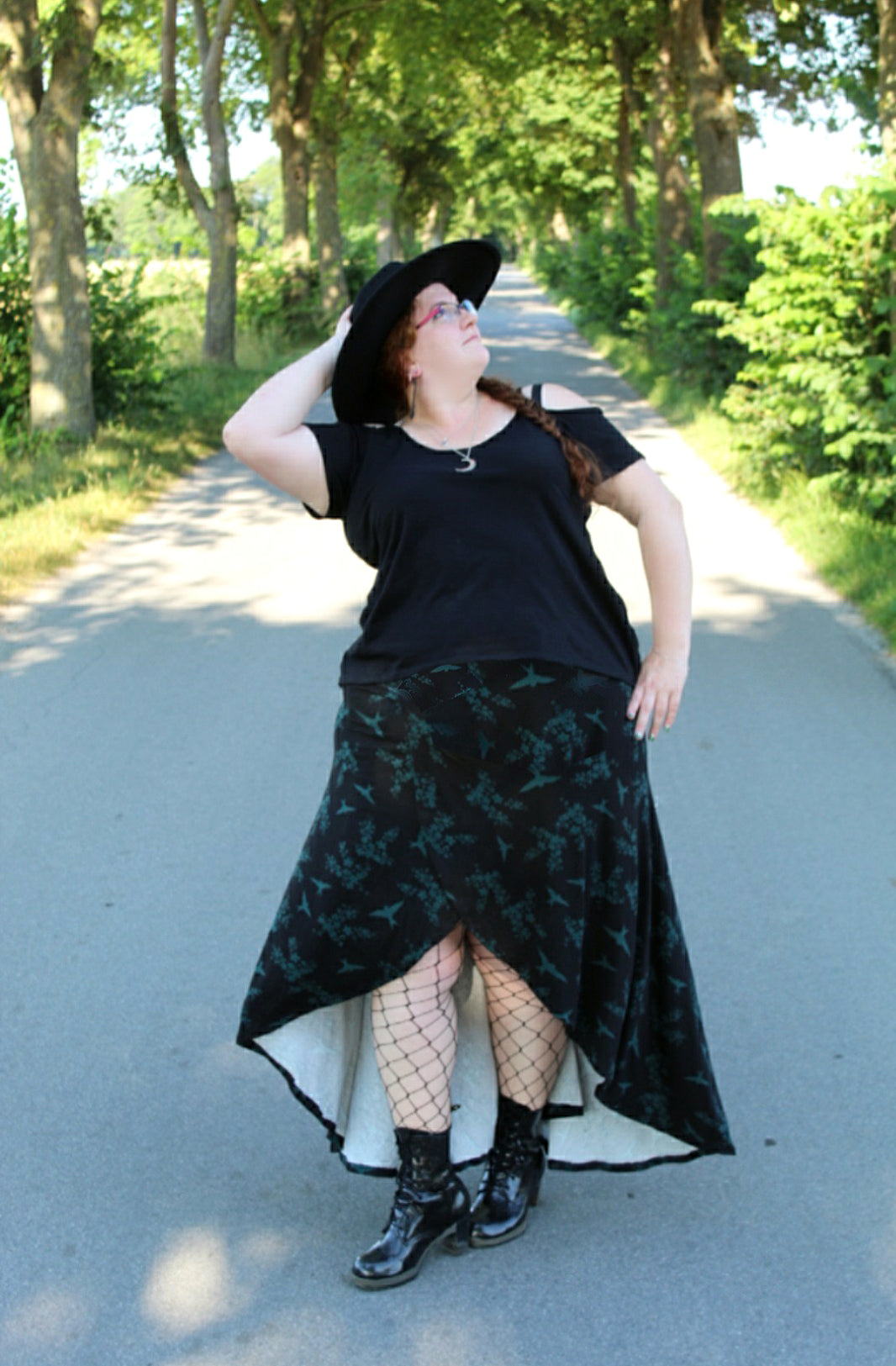 Plus size skort sewing pattern with built-in shorts. Easy knit sewing pattern with video tutorial. Model with black print knit fabric skort. Wrap front with high-low hemline. DIY skirt.