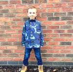 Boy wearing a blue camo print jacket with buttons up the front. Easy sewing pattern for kids.