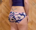 Woman modeling a navy floral low-rise panty with light pink picot elastic. They panties were made using the Feel Frisky Panties sewing pattern. 
