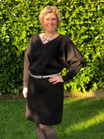 Woman wearing an elegant black scuba crossover wrap dress PDF pattern with fitted pencil skirt