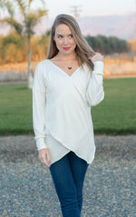 Woman wearing a white stylish faux wrap top standing outside. This was made using the crossover top and dress sewing pattern with adjustable options