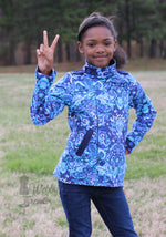 Ellie & Mac Kids Duke Jacket sewing pattern worn by a girl giving the peace sign. The jacket is made in a beautiful purple and blue print woven fabric with pockets, and accent bands. Easy jacket sewing pattern for kids.