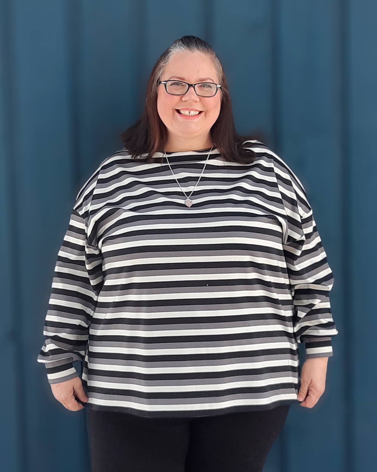 Woman wearing an oversized striped sweater she made using Ellie and Mac patterns.