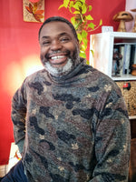 Man wearing a cozy camo turtleneck sweater with a big smile on his face.