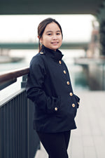 Ellie & Mac Kids Duke Jacket sewing pattern worn by a girl with black fabric.