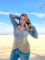 Woman wearing a grey Crossover faux wrap sweater sewing pattern that crosses at the waist and hips
